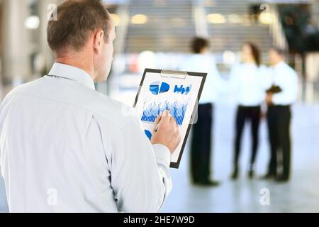 Buchhaltung. Geschäftsmann mit dem Finanzplan der Einnahmen des Unternehmens Stockfoto