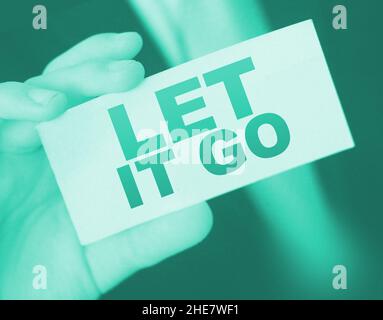 Nahaufnahme auf Geschäftsmann mit einer Karte mit Text LASSEN SIE ES GEHEN, Geschäftskonzept Bild mit weichem Fokus Hintergrund und vintage Ton. Stockfoto