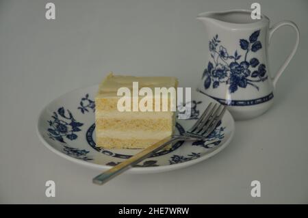 Feines Porzellanset für Kaffee-Tee und Käsekuchen auf Teller. Tee im Stil der alten Schule am Nachmittag mit Kuchen, süßen traditionellen Tisch, Käsekuchen sug Stockfoto