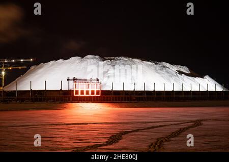 HAPPI. Lichtkunst-Installation von Jari Vuorinen beim Lux Helsinki Light Art Festival. Beleuchteter schneebedeckter Kohlebestand in Hanasaari. Stockfoto