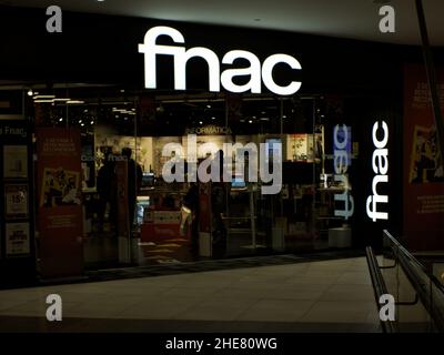 Sevilla, Spanien; 4th. Januar 2021: Nachtfoto des Eingangs und der Schaufensterfront des FNAC-Shops im Einkaufszentrum Torre Sevilla. Stockfoto