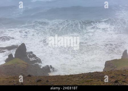 Stürmisches Wasser in Island und der Highway 1 führt direkt am Meer entlang. Stockfoto