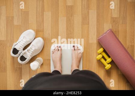 Frau Füße auf einer Waage, Blick auf die erste Person. Fitness, sich in Form zu bringen und das Gewicht zu Hause zu kontrollieren Konzept Stockfoto