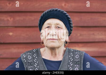 Porträt einer asiatischen älteren Frau in traditioneller Kleidung, die in einem sibirischen Dorf in Russland lebt Stockfoto