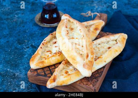 Türkisches Pide mit Käse, beliebtes Straßenessen in der Türkei. Holzhintergrund. Nahaufnahme. Stockfoto