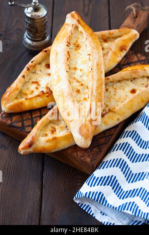 Türkisches Pide mit Käse, beliebtes Straßenessen in der Türkei. Holzhintergrund. Nahaufnahme. Stockfoto