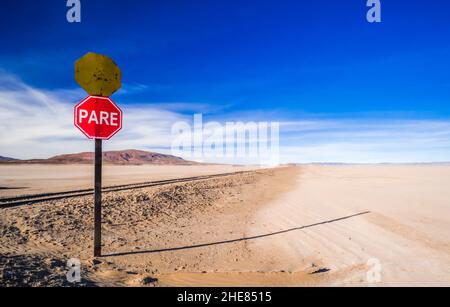 Stoppschild neben der alten Eisenbahn in Salar de Uyuni, Bolivien Stockfoto