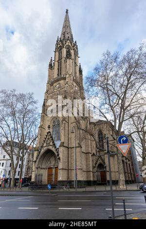 Katholische Kirche 'Herz Jesu' steht bei Winterwetter in Köln mit zufälligen Menschen, die vor uns gehen Stockfoto