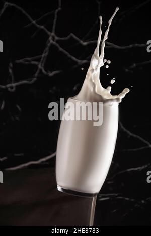 Stop-Motion-Shot eines Glases voller Milch auf der schwarzen Marmoroberfläche Stockfoto