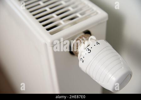 Temperatur am Heizkörperthermostat einstellen, Heizkörperregler drehen, um die Wärme zu Hause zu steuern Stockfoto