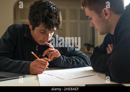 Jungen lernen zusammen. Ältere Schüler hilft bei den Hausaufgaben Stockfoto