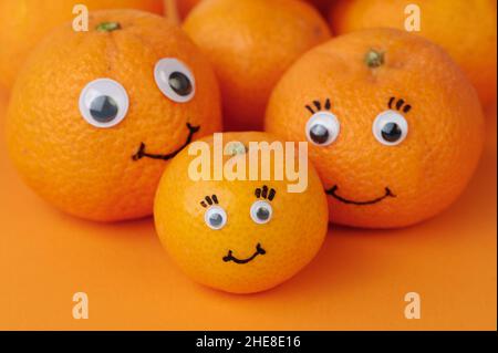 Fröhliche Mandarinen Mit Lustigen Gesichtern Auf Orangefarbenem Hintergrund Stockfoto