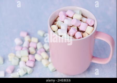 Rosa Tasse Mit Heißer Schokolade, Darin Viele Kleine Bunte Marshallows Auf Blauem Hintergrund Stockfoto