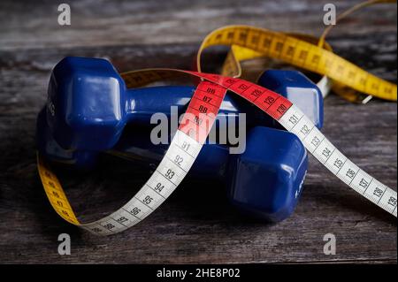 Zwei Blue Fitness Kurzhanteln Mit Tapeline Auf Holzhintergrund Stockfoto