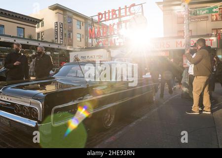 Seattle, USA. 9 Januar 2022. Eine Lowrider-Gruppe taetup auf dem Pike Place Market, während Touristen und Einheimische spät am Tag Fotos machen. Oldtimer-Gruppen nutzen den Mangel an Menschen in der Innenstadt, um ihre Oldtimer durch die Stadt zu fahren und Fotos zu machen. Quelle: James Anderson/Alamy Live News Stockfoto