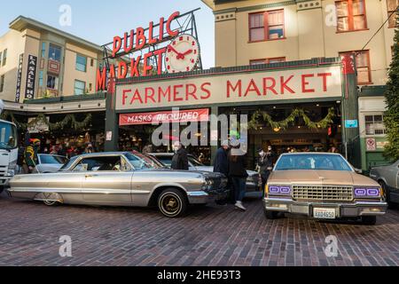 Seattle, USA. 9 Januar 2022. Eine Lowrider-Gruppe taetup auf dem Pike Place Market, während Touristen und Einheimische spät am Tag Fotos machen. Oldtimer-Gruppen nutzen den Mangel an Menschen in der Innenstadt, um ihre Oldtimer durch die Stadt zu fahren und Fotos zu machen. Quelle: James Anderson/Alamy Live News Stockfoto