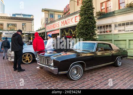 Seattle, USA. 9 Januar 2022. Eine Lowrider-Gruppe taetup auf dem Pike Place Market, während Touristen und Einheimische spät am Tag Fotos machen. Oldtimer-Gruppen nutzen den Mangel an Menschen in der Innenstadt, um ihre Oldtimer durch die Stadt zu fahren und Fotos zu machen. Quelle: James Anderson/Alamy Live News Stockfoto