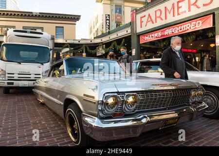 Seattle, USA. 9 Januar 2022. Eine Lowrider-Gruppe taetup auf dem Pike Place Market, während Touristen und Einheimische spät am Tag Fotos machen. Oldtimer-Gruppen nutzen den Mangel an Menschen in der Innenstadt, um ihre Oldtimer durch die Stadt zu fahren und Fotos zu machen. Quelle: James Anderson/Alamy Live News Stockfoto