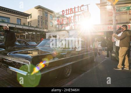 Seattle, USA. 9 Januar 2022. Eine Lowrider-Gruppe taetup auf dem Pike Place Market, während Touristen und Einheimische spät am Tag Fotos machen. Oldtimer-Gruppen nutzen den Mangel an Menschen in der Innenstadt, um ihre Oldtimer durch die Stadt zu fahren und Fotos zu machen. Quelle: James Anderson/Alamy Live News Stockfoto