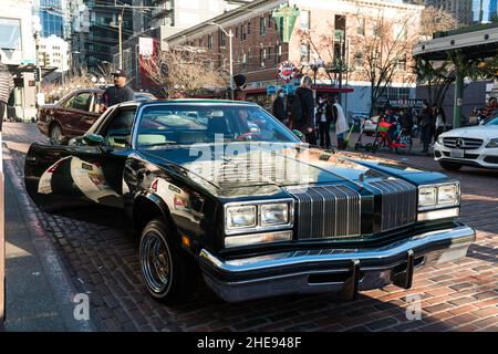 Seattle, USA. 9 Januar 2022. Eine Lowrider-Gruppe taetup auf dem Pike Place Market, während Touristen und Einheimische spät am Tag Fotos machen. Oldtimer-Gruppen nutzen den Mangel an Menschen in der Innenstadt, um ihre Oldtimer durch die Stadt zu fahren und Fotos zu machen. Quelle: James Anderson/Alamy Live News Stockfoto