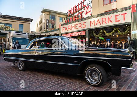 Seattle, USA. 9 Januar 2022. Eine Lowrider-Gruppe taetup auf dem Pike Place Market, während Touristen und Einheimische spät am Tag Fotos machen. Oldtimer-Gruppen nutzen den Mangel an Menschen in der Innenstadt, um ihre Oldtimer durch die Stadt zu fahren und Fotos zu machen. Quelle: James Anderson/Alamy Live News Stockfoto