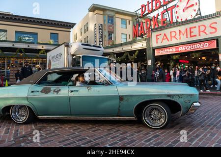 Seattle, USA. 9 Januar 2022. Eine Lowrider-Gruppe taetup auf dem Pike Place Market, während Touristen und Einheimische spät am Tag Fotos machen. Oldtimer-Gruppen nutzen den Mangel an Menschen in der Innenstadt, um ihre Oldtimer durch die Stadt zu fahren und Fotos zu machen. Quelle: James Anderson/Alamy Live News Stockfoto