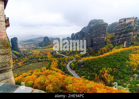 Blick vom Kloster St. Barbara oder Roussanou in Meteora, Griechenland unter nebligen, bewölkten Himmel mit Herbstfärbung der Blätter. Stockfoto