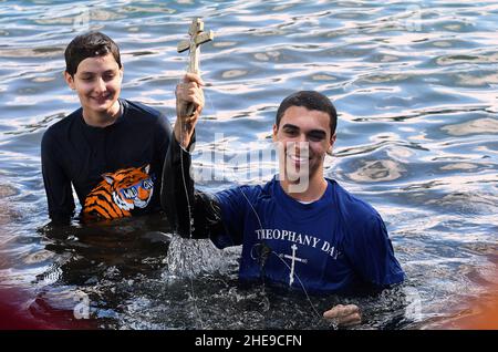 Orlando, Usa. 09th Januar 2022. Isaac Abdelmessih hält das Kreuz, nachdem er es vom Eola-See während des jährlichen Epiphany-Kreuztauchgangs der St. George Orthodox Church in der Innenstadt von Orlando abgerufen hat. Die Feier ehrt die Taufe Jesu Christi und es heißt, dass die Person, die das Kreuz abholt, für den Rest des Jahres Glück erhalten wird. Kredit: SOPA Images Limited/Alamy Live Nachrichten Stockfoto