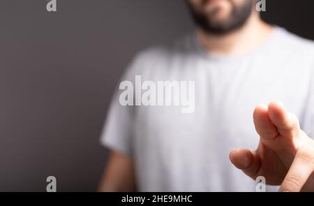 Flacher Fokus einer menschlichen Hand, die auf einen leeren Luftraum mit Kopierraum zeigt Stockfoto