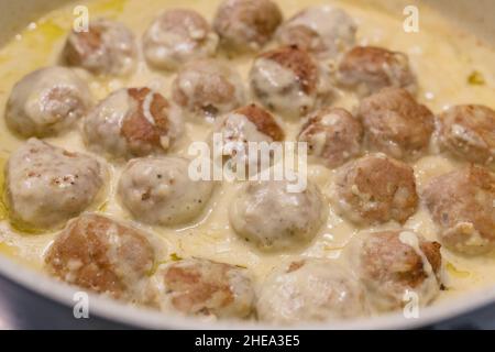 Schwedische Fleischbällchen in einer cremigen weißen Sauce Rezept. Fleischbällchen in der Pfanne aus nächster Nähe Stockfoto