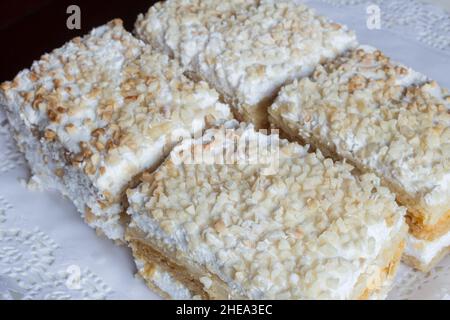 Millefeuille aus Blätterteig und gefüllt mit Backcreme und Baiser. Das Dessert wird mit gerösteten gehackten Mandeln und Puderzucker gekrönt. Simp Stockfoto