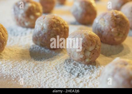 Ungekochte Fleischbällchen schließen sich auf ein Holzbrett, das von einem Mehl gegossen wird. Schwedische Fleischbällchen in einer cremigen weißen Sauce Schritt für Schritt Rezept Stockfoto