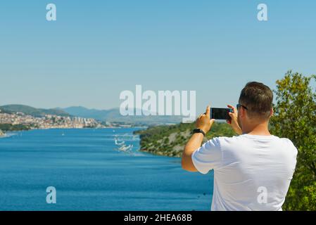 Blogger fotografieren auf seinem Handy-Kamera von einer schönen Landschaft. Mann schießt Video auf Handy während erstaunliche Reise durch die Stockfoto