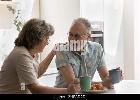 Fröhliche ältere Frau im Gespräch mit einem lachenden alten Mann. Stockfoto