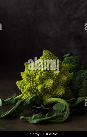 Romanesco Kohl und Brokkoli Nahaufnahme auf dunklem Hintergrund Stockfoto