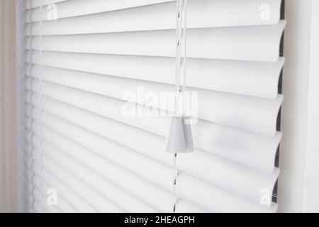 Weiße Jalousien am Fenster mit weißem Kunststoff Stockfoto