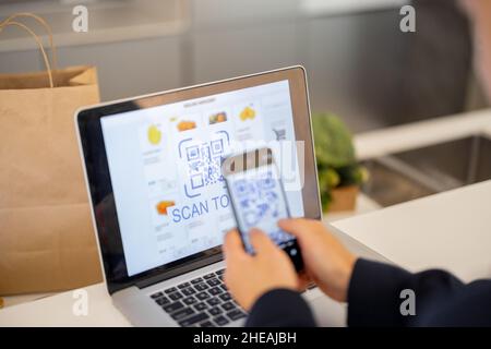 Mann mit Smartphone für die Zahlung im Online-Shop Stockfoto