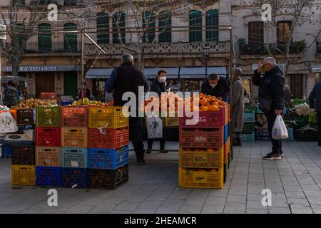 Llucmajor, Spanien; januar 07 2022: Wöchentlicher Straßenmarkt in der mallorquinischen Stadt Llucmajor. Anbieter und Kunden mit Masken aufgrund von Einschränkungen durch den Stockfoto