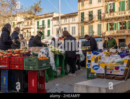 Llucmajor, Spanien; januar 07 2022: Wöchentlicher Straßenmarkt in der mallorquinischen Stadt Llucmajor. Anbieter und Kunden mit Masken aufgrund von Einschränkungen durch den Stockfoto