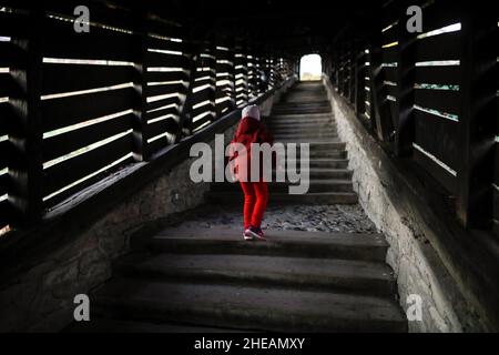 Sighisoara, Rumänien - 30. Oktober 2021: Kleines Mädchen geht die berühmte überdachte Treppe (Scara acoperita) oder die Treppe der Gelehrten hinauf, die von t Stockfoto