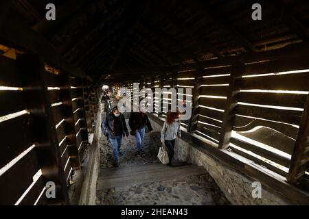 Sighisoara, Rumänien - 30. Oktober 2021: Die Menschen gehen die berühmte überdachte Treppe (Scara acoperita) oder die Treppe der Gelehrten, die hinauf führt, auf und ab Stockfoto