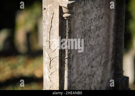 Sighisoara, Rumänien - 30. Oktober 2021: Details zur geringen Schärfentiefe (selektiver Fokus) mit dem Text in alter deutscher Sprache und Schriften auf einem Grab. Stockfoto