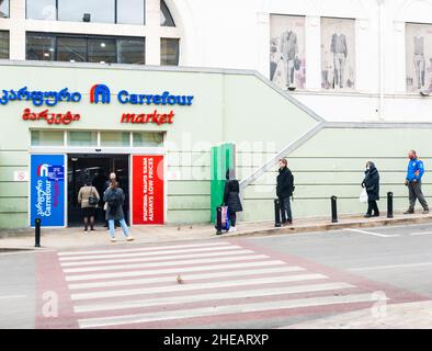 Kunden vor dem carrefour-Supermarkt stehen Schlange. Einkaufen während Quarantäne und neue Vorschriften wegen Pandemie in Georgien.Tiflis. 09.04.2020 Stockfoto