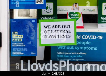 Schild „Wir haben keine lateralen Durchflusstests mehr“ und Covid-19-Informationsschilder im Fenster der Lloyds Pharmacy in High Street, Winchester, Hampshire, England Stockfoto