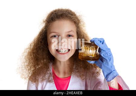 Halblanges Porträt von niedlichen schönen kleinen Mädchen, Kind in Bild von Zahnarzt Arzt trägt weißen Laborkittel und Handschuhe isoliert auf weißem Studio Stockfoto