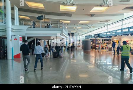 Porto Portugal 09 19 2021: SA Carneiro Flughafen Innenansicht, Abflüge und Ankünfte, innerhalb von Geschäften und Menschen, die mit Koffern und Tasche zu Fuß gehen Stockfoto