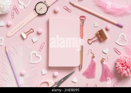 Hardcover-Notizbuch, Rosa Schulzubehör und Herzen auf hellrosa, Draufsicht, Textbuch-Modell. Girly Arbeitsplatz mit Notebook, Schere, Bleistift, Stift, Stockfoto