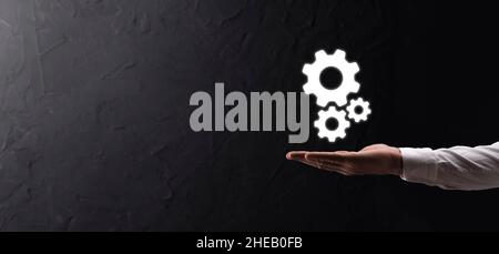 Hand hält Metall Zahnräder und Zahnräder Mechanismus der Interaktion Teamwork Konzept, Hand halten Gruppe von virtuellen Zahnräder Rad. Stockfoto
