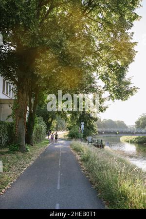 Straßburg, Frankreich - 29. Jul 2019: Große Fußgängerallee mit ein paar Läufern, die Wasser trinken, und Radfahrern im Hintergrund Stockfoto