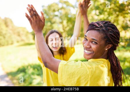 Glückliche afrikanerin gibt hohe fünf für die Motivation im Sommer in der Natur Stockfoto